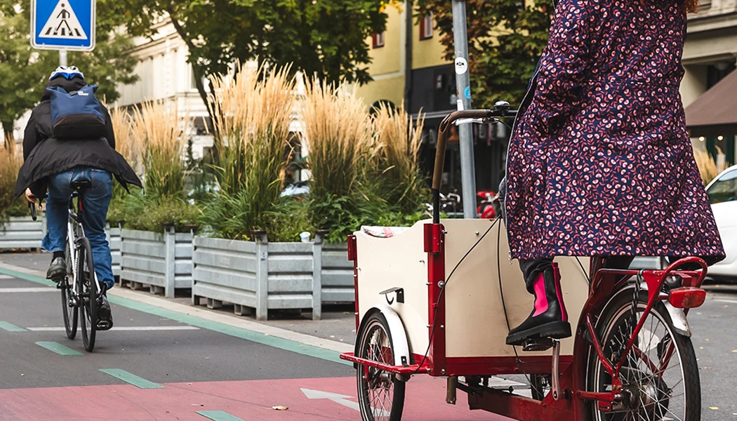 Person, die mit einem Lastenfahrrad auf einer roten Fahrradspur fährt